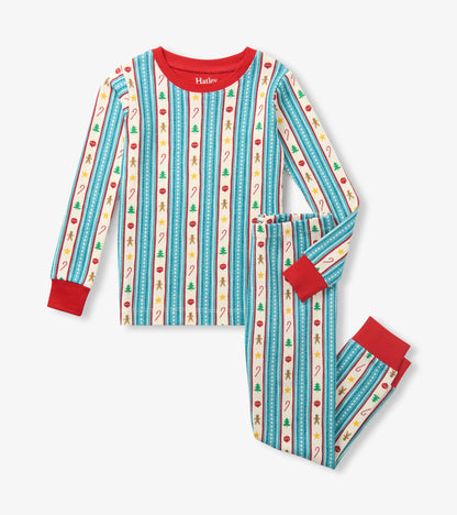 Kids holiday pajama set with red trim and striped print featuring trees, candy canes, stars, ornaments, and gingerbread