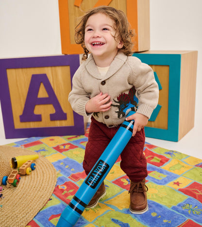 Toddler modeling an oatmeal dinosaur cardigan with shawl collar and button front