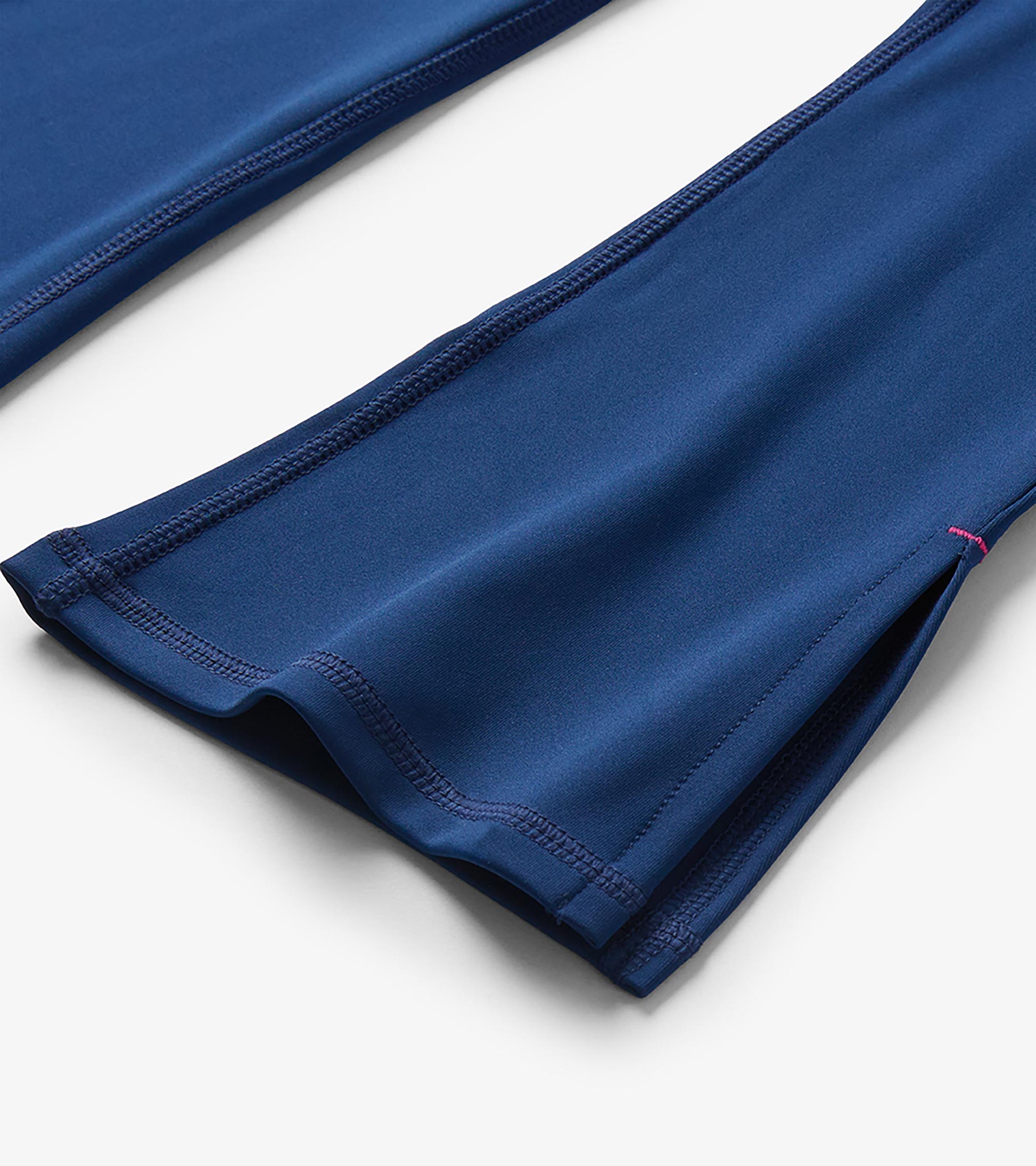 Close-up of the hem on girls estate blue flared active pants showing the side slit and seam detail