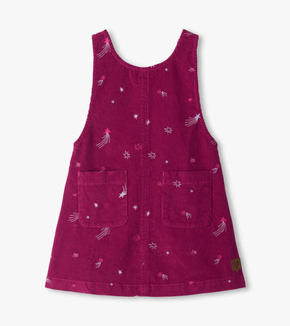 Front view of berry pinafore dress with embroidered shooting stars, scattered stars, and two front patch pockets