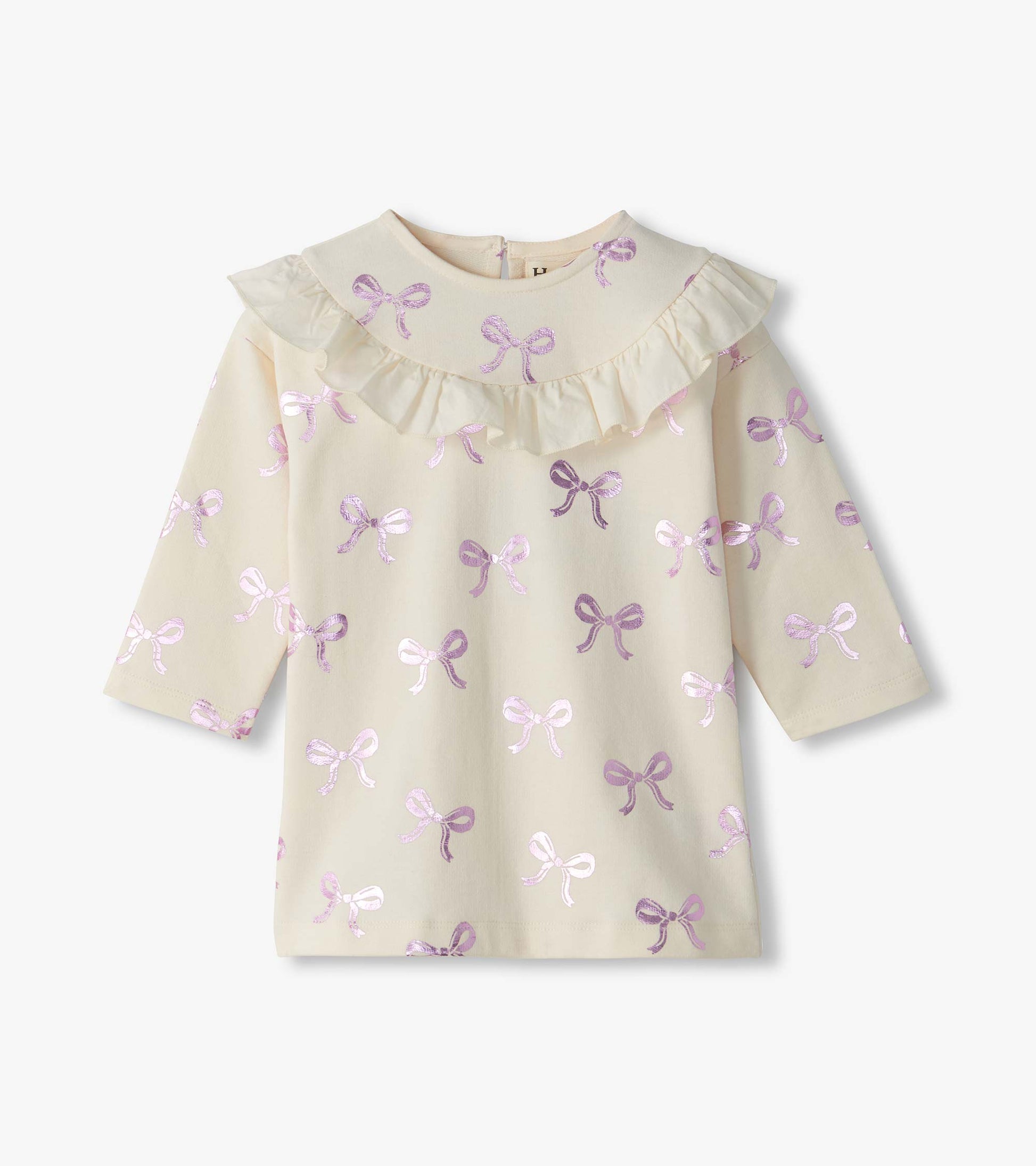 Front view of cream infant dress with pink foil bow print, ruffle yoke, and long sleeves