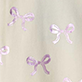 Light beige surface with three purple ribbon bow designs and two small pearl-like circles