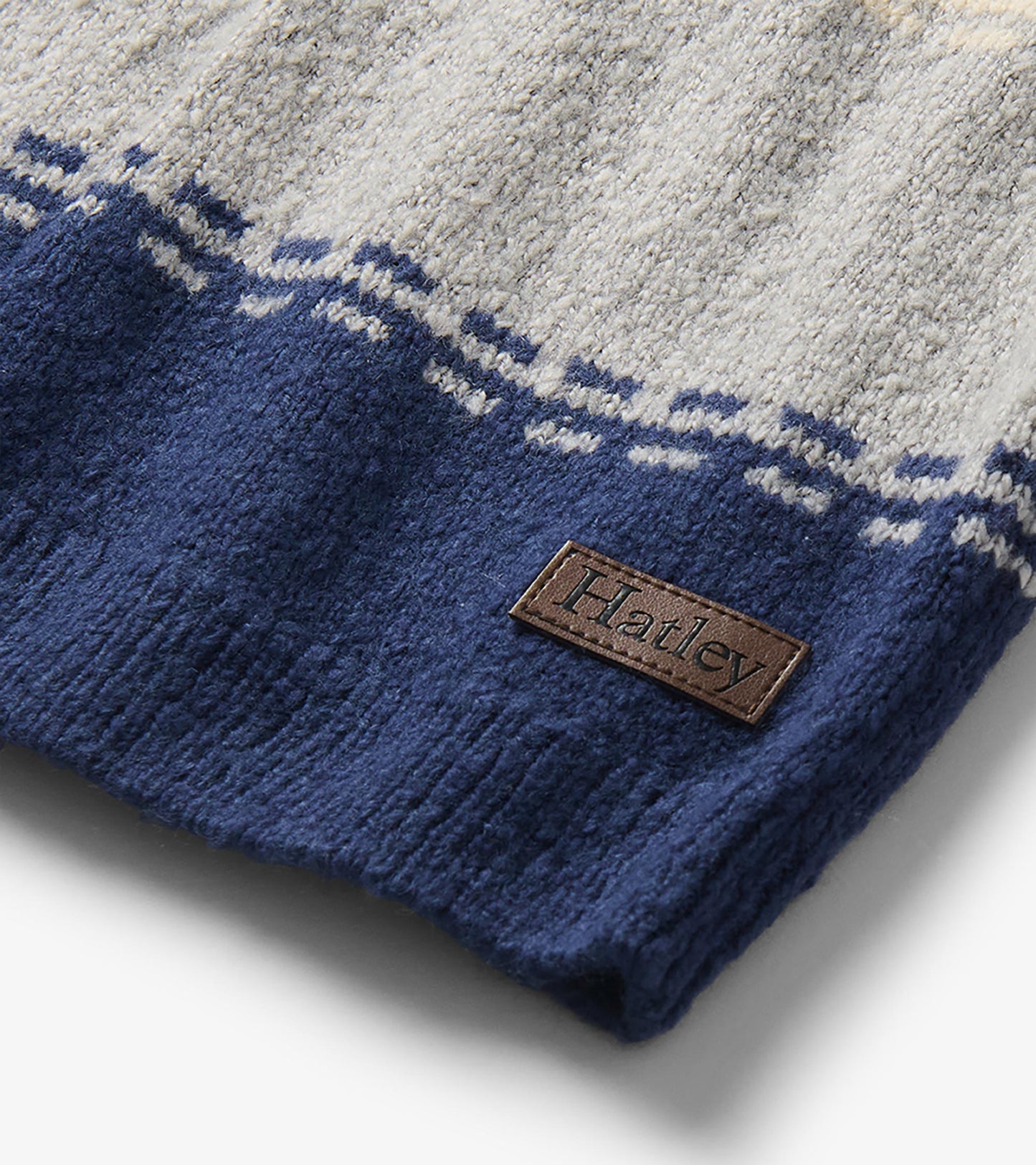 Close-up of navy hem on colourblock sweater with grey stripe detail and visible Hatley logo patch
