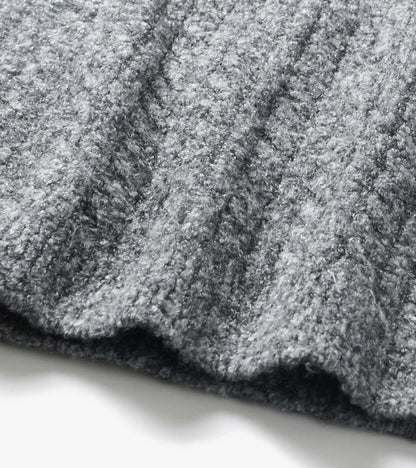 Close-up of grey boucle sweater fabric with a soft, curly texture