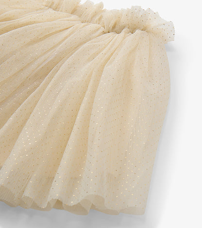 Close-up of cream tulle tutu skirt showing gold glitter dots and gathered elastic waistband