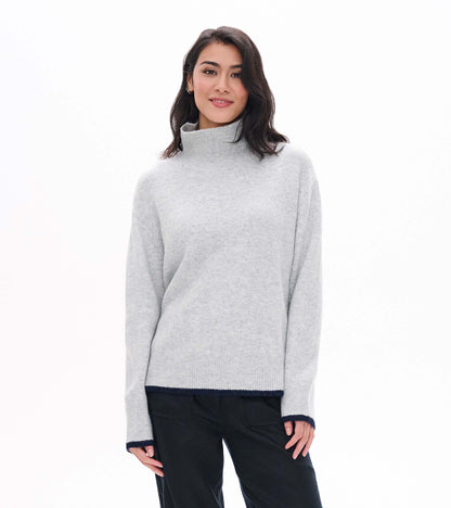 Front view of athletic grey mock neck sweater with ribbed collar and navy trim at cuffs and hem