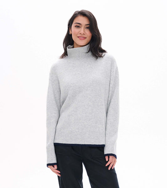 Front view of athletic grey mock neck sweater with ribbed collar and navy trim at cuffs and hem