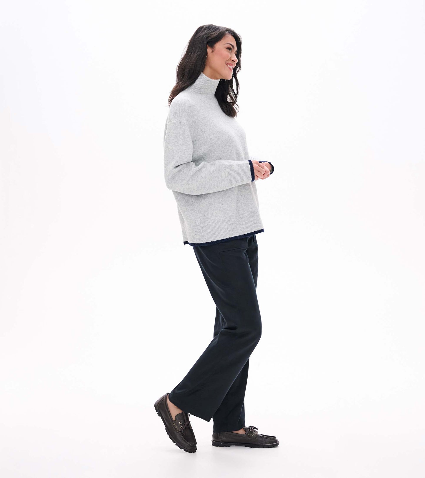 Side view of athletic grey mock neck sweater with relaxed fit and navy trim at cuffs and hem