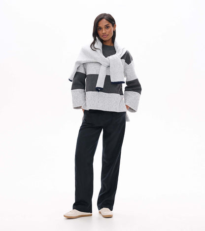 Front view of charcoal and light gray striped long sleeve top with wide cuffs and relaxed fit
