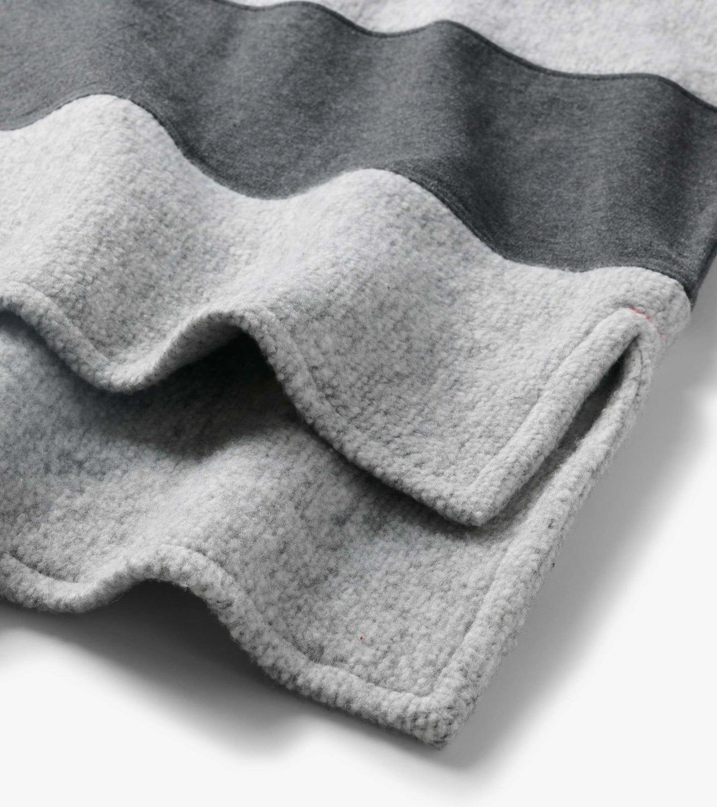 Close-up of the top showing charcoal and light gray stripes with textured fabric and wavy seams