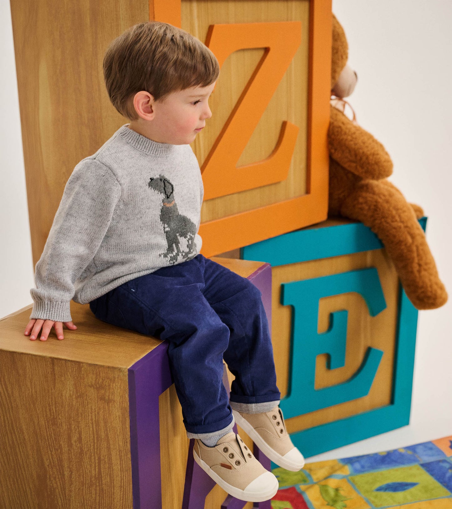 Toddler wearing a heather gray crew neck sweater with a black Labrador graphic on the front