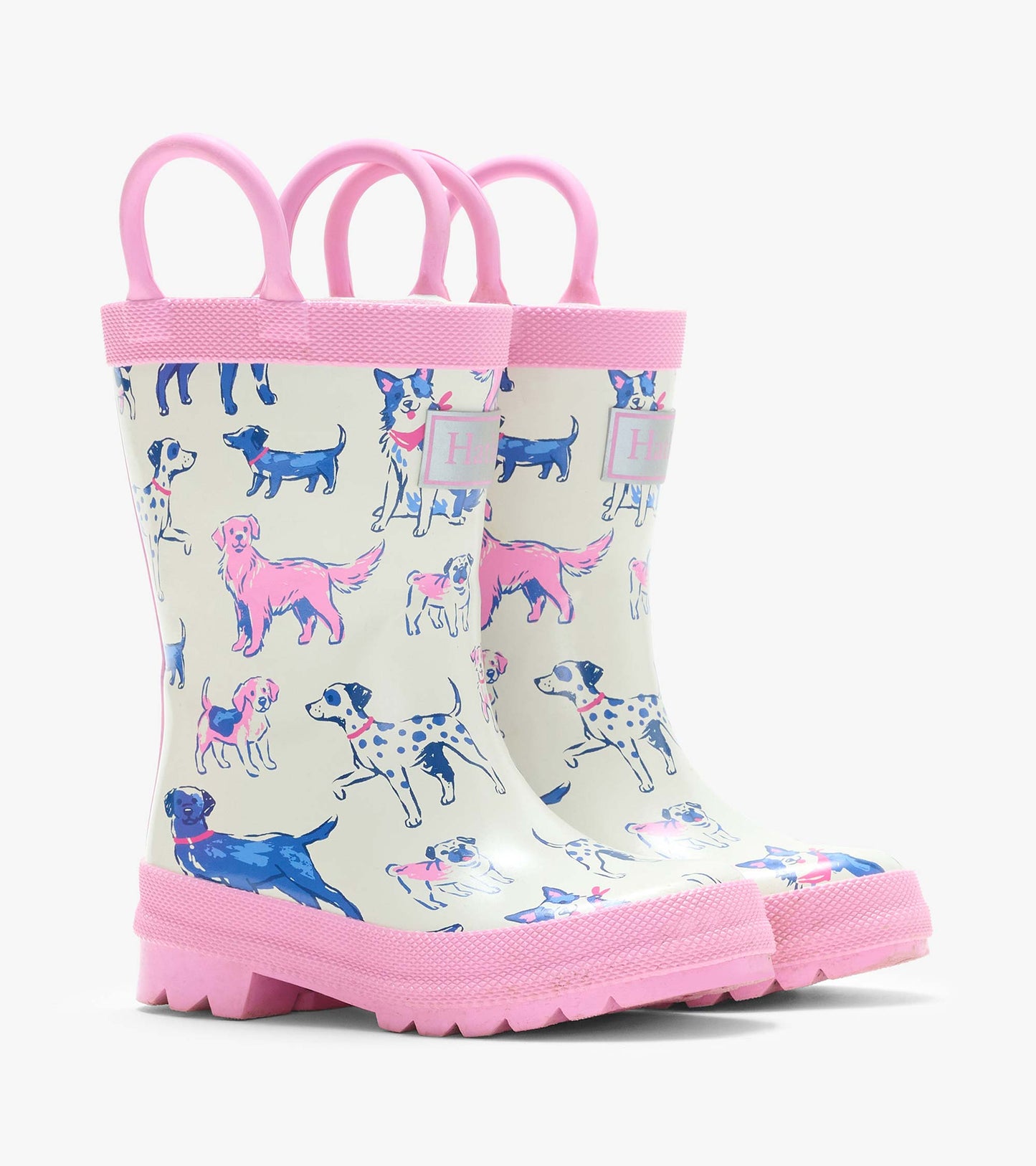 Pair of cream kids rain boots with pink handles, pink trim, and blue and pink dog print