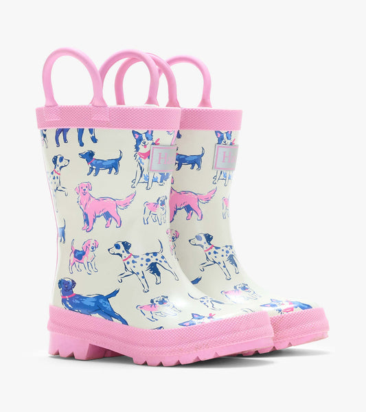 Pair of cream kids rain boots with pink handles, pink trim, and blue and pink dog print