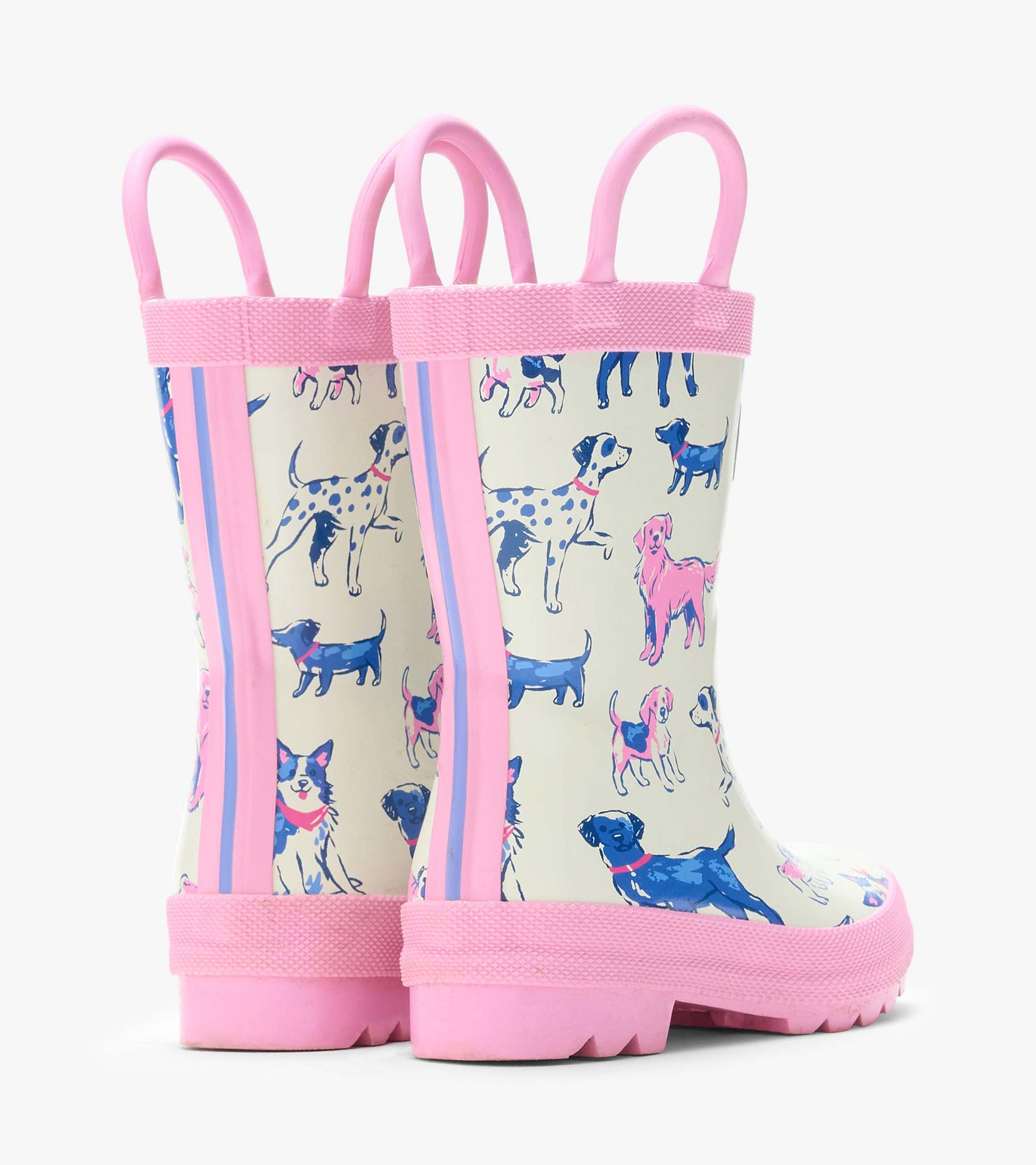 Rear angled view of cream rain boots with pink handles and trim and blue and pink dog print