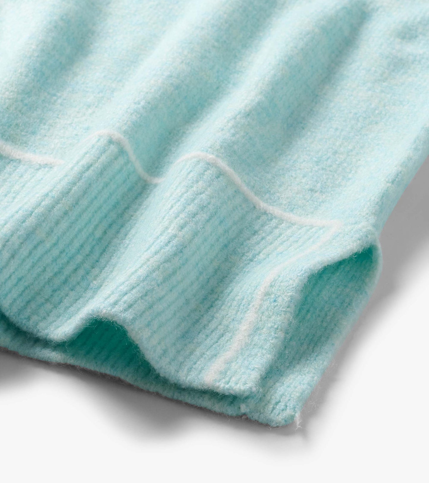Close-up of the teal Digital Stripe Sweater hem with ribbed knit trim