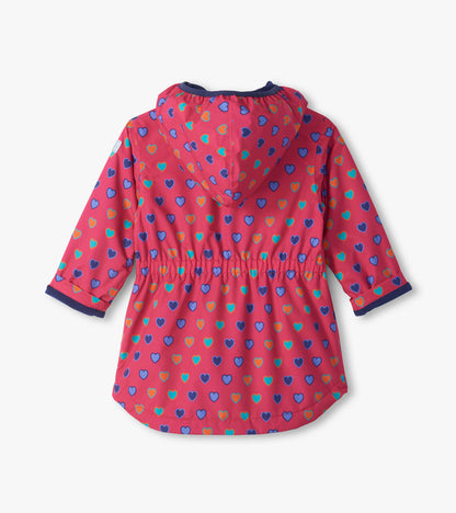 Back view of pink kids field jacket with blue, teal, and orange heart print, hood, and gathered waist