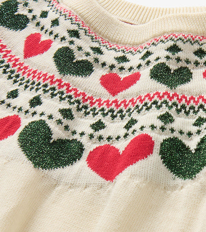 Close-up of cream knit neckline with red and dark green heart pattern and holiday-style trim