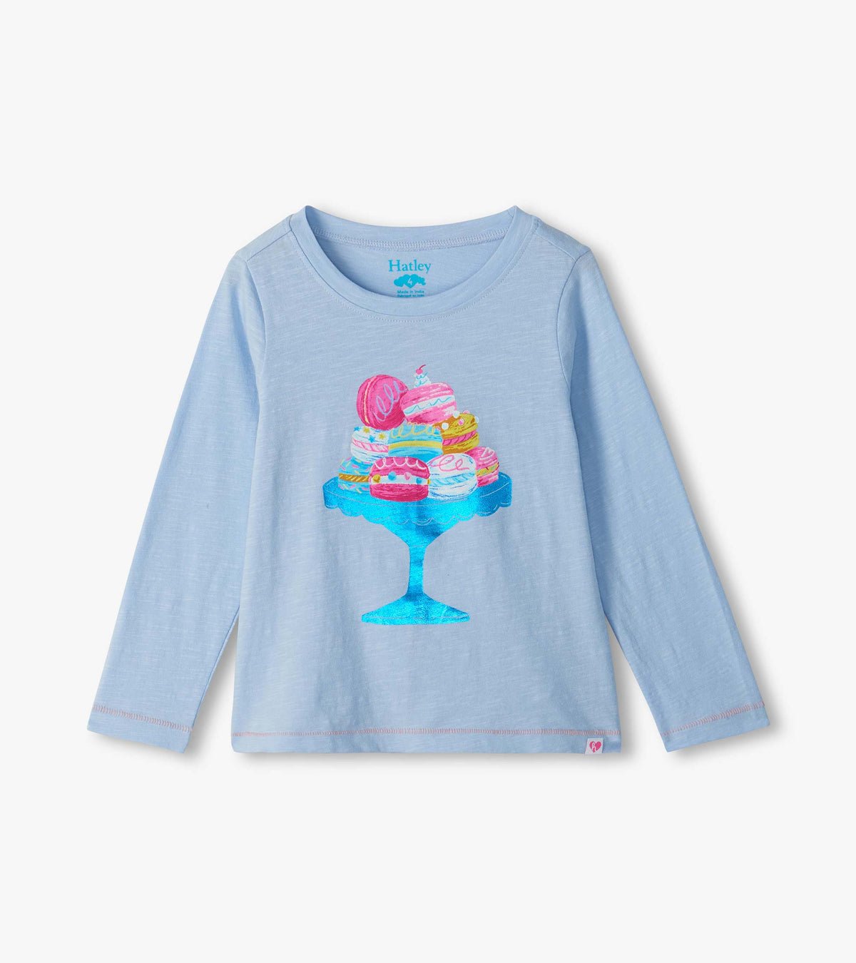 Light blue girls long-sleeve T-shirt with colorful macaron graphic on a blue cake stand