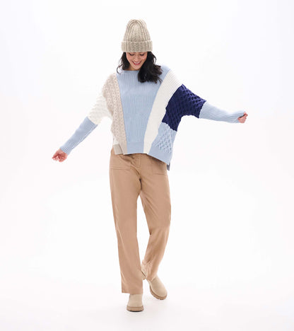 Front view of blue mixed-pattern sweater with cream and navy color blocking and long ribbed sleeves