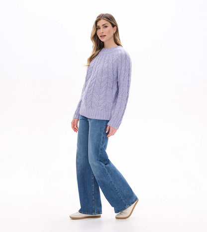 Speckled lilac cable knit sweater shown from the side with ribbed hem and cuffs