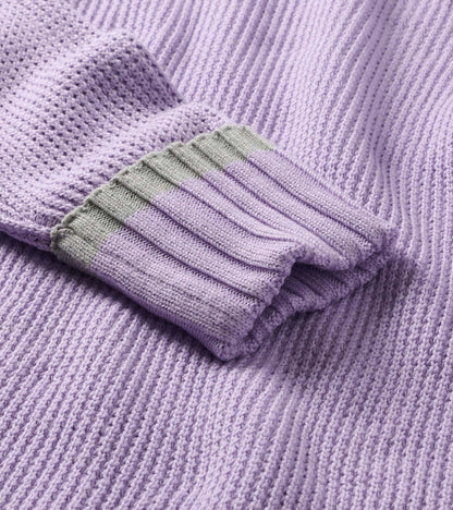 Close-up of lilac waffle knit sweater sleeve with ribbed cuff and light gray trim