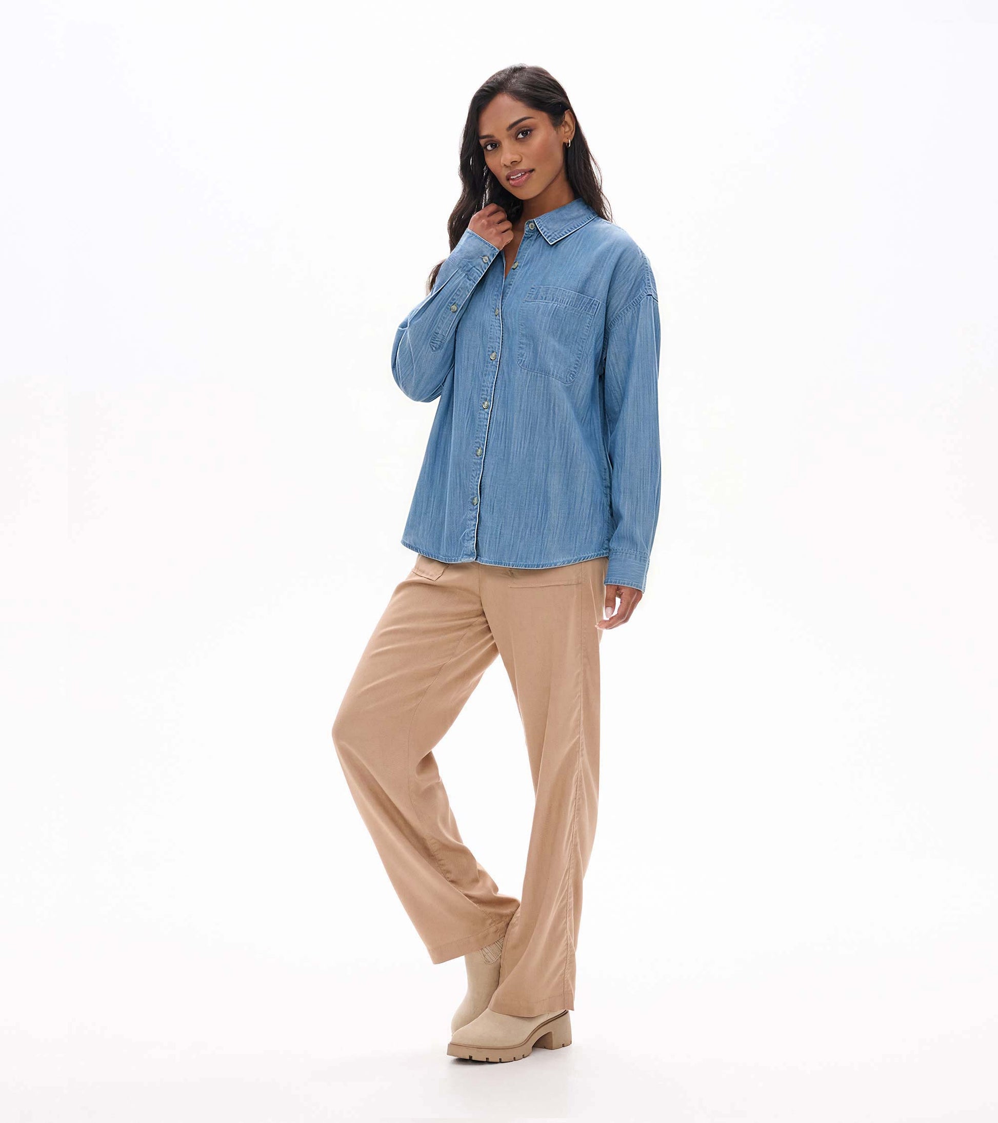 Angled front view of light blue wash button-down shirt on model with collar, chest pocket, and long sleeves