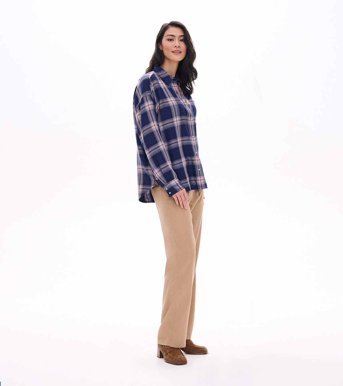 Side view of relaxed navy plaid button-down shirt with long sleeves and curved hem on model