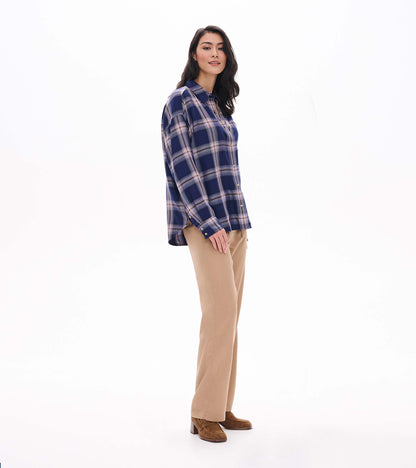 Side view of relaxed navy plaid button-down shirt with long sleeves and curved hem on model
