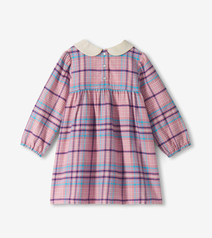 Back view of mauve plaid toddler dress with long sleeves, gathered waist, cream collar, and snap closure