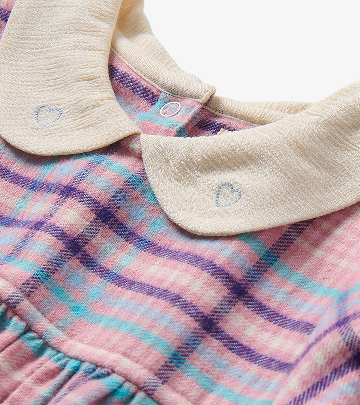 Close-up of cream Peter Pan collar with embroidered hearts on mauve plaid toddler dress