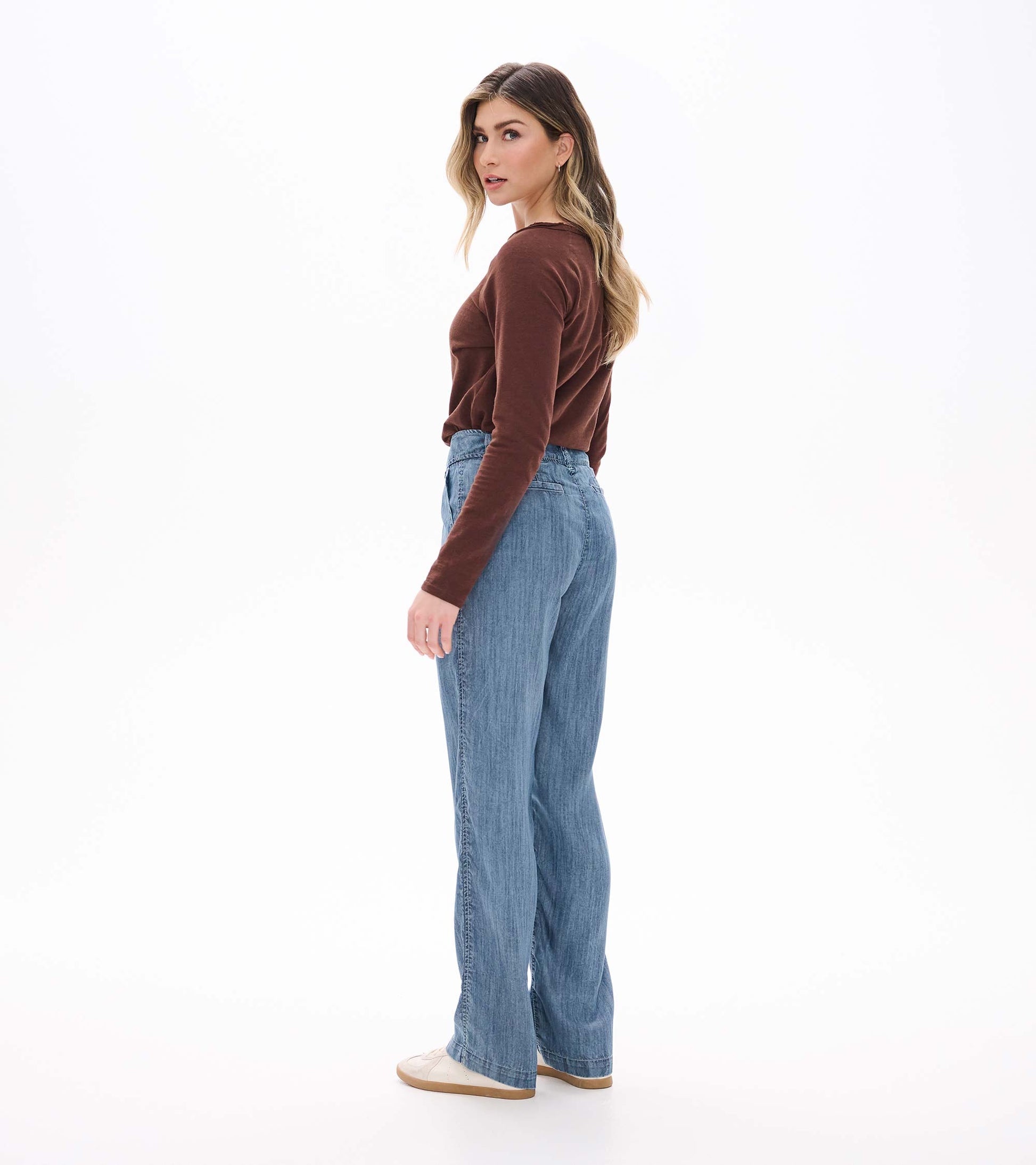 Blue acid rinse wide leg pants on model from side-back angle with high waist and wide legs