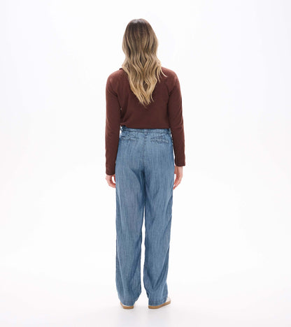 Back view of blue acid rinse wide leg pants on model with high waist and back welt pockets
