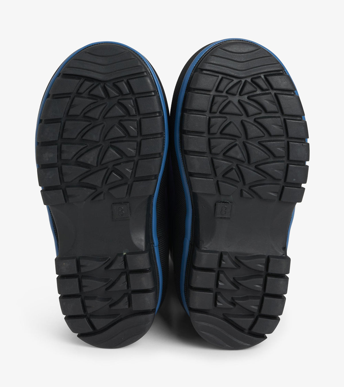 Bottom view of black lug soles with textured tread pattern on navy kids boots