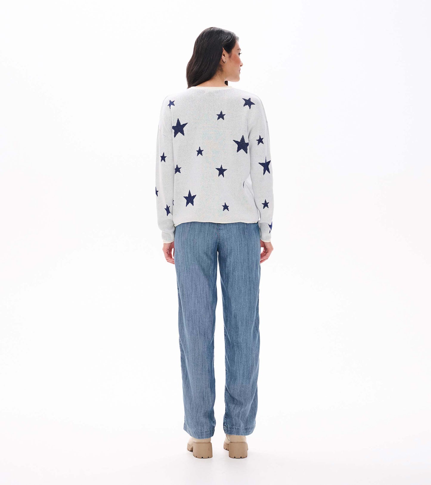 Back view of cream sweater with scattered navy stars and rolled hem