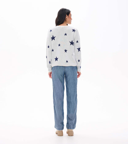 Back view of cream sweater with scattered navy stars and rolled hem