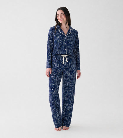 Model wearing navy polka dot pajama set with white piping and drawstring pants, front view