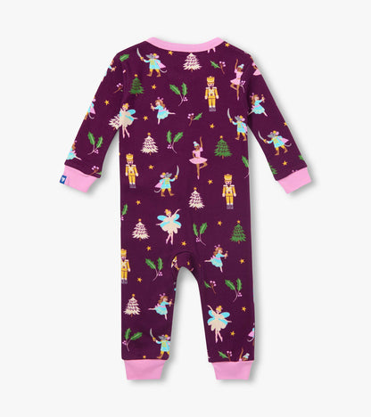 Back view of infant coverall in deep purple with pink cuffs and holiday print of nutcrackers, ballerinas and trees