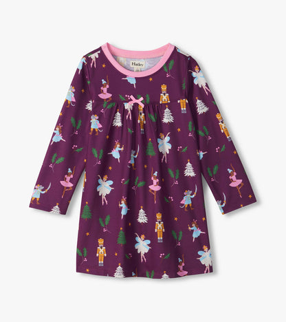 Front view of girls' purple nightdress with pink trim and bow, featuring a Nutcracker holiday print