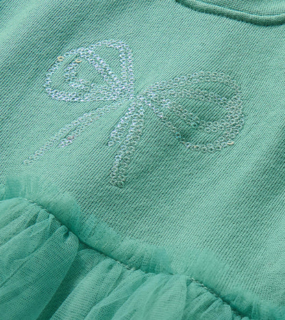 Close-up of the chest showing a sequin bow detail on the oil blue dress