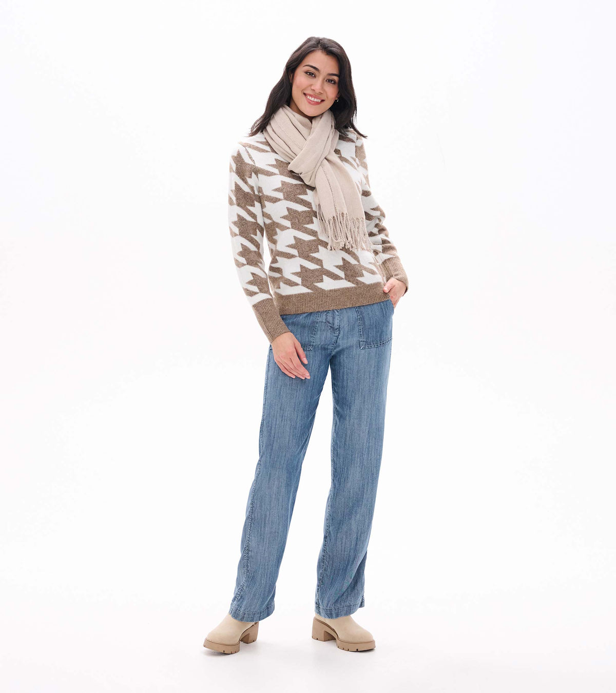 Front view of oatmeal and cream herringbone sweater styled with a light beige scarf