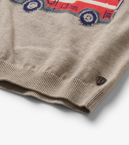 Close-up of oatmeal marl sweater hem with partial firetruck graphic and small Hatley badge
