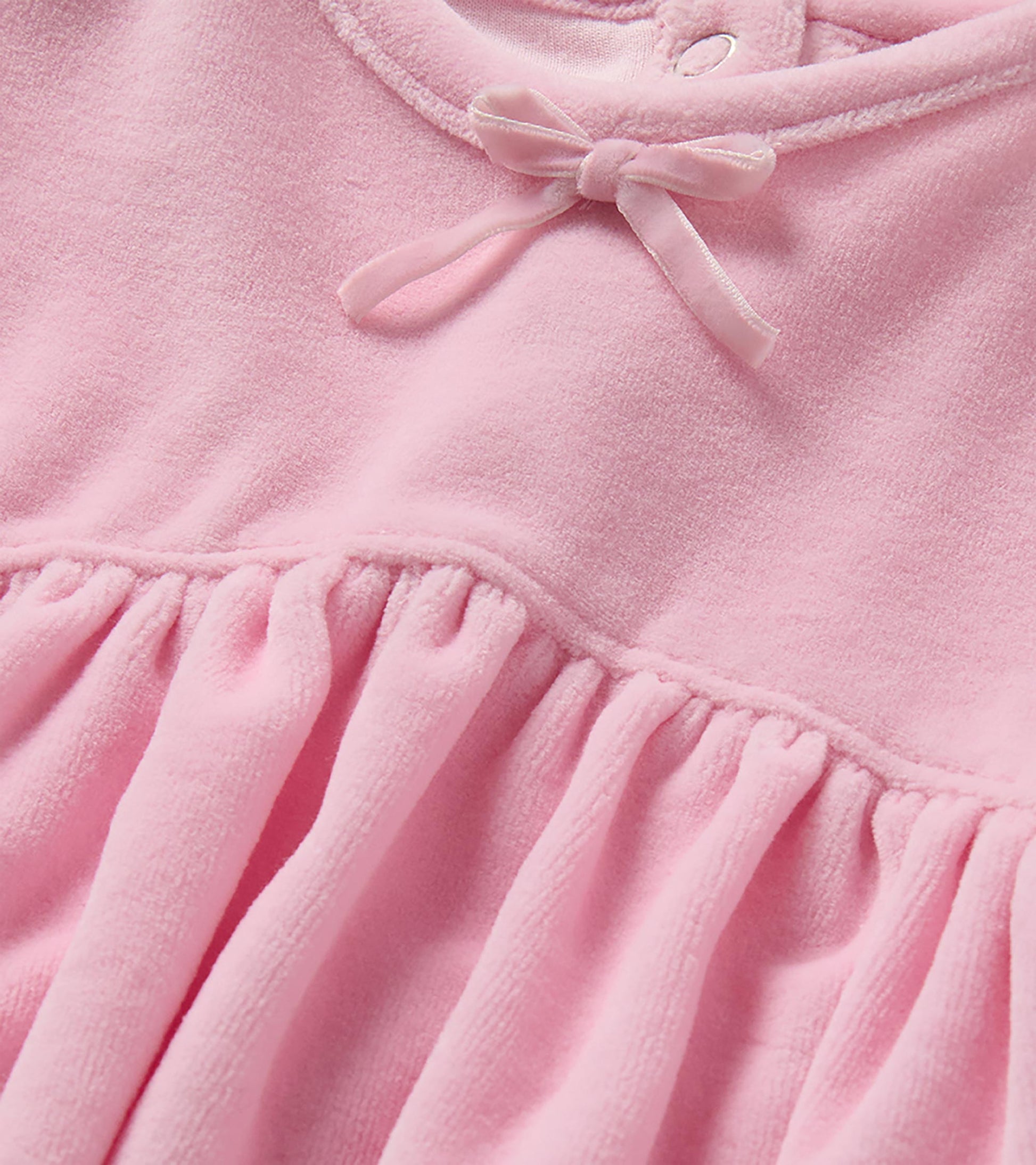 Close-up of orchid pink dress neckline with small bow and gathered waist seam