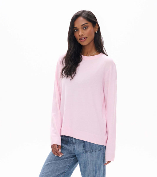 Model wearing pale pink boyfriend sweater with crew neck and ribbed hem, angled front view
