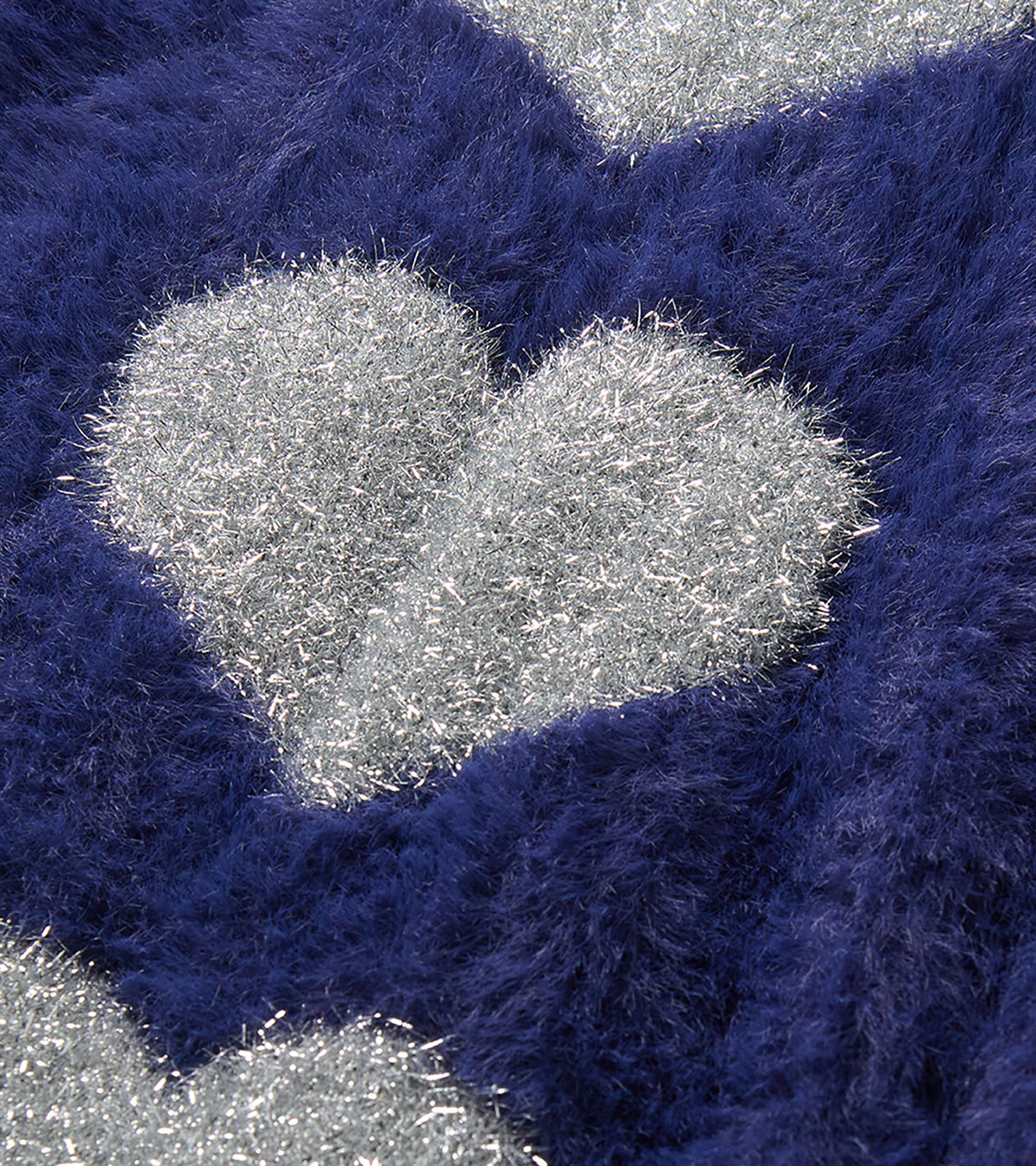 Close-up of blue fuzzy sweater dress with silver heart detail
