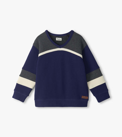 Front view of kids blue pullover top with gray yoke, cream curved chest stripe, and striped sleeves