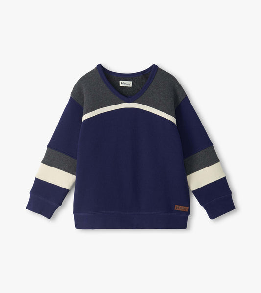 Front view of kids blue pullover top with gray yoke, cream curved chest stripe, and striped sleeves