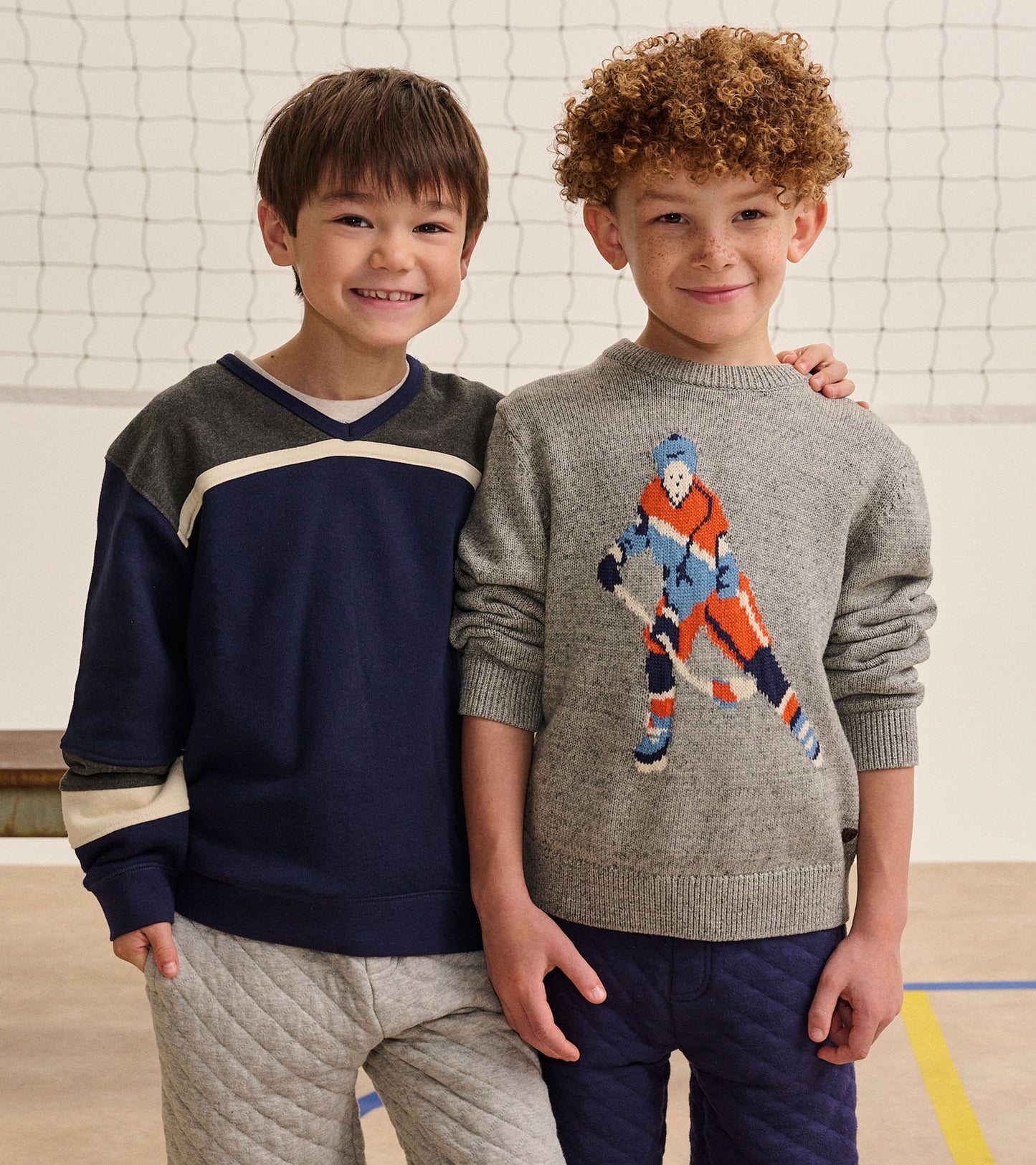 Boy wearing patriot blue pullover with charcoal yoke and cream stripe, standing beside another child
