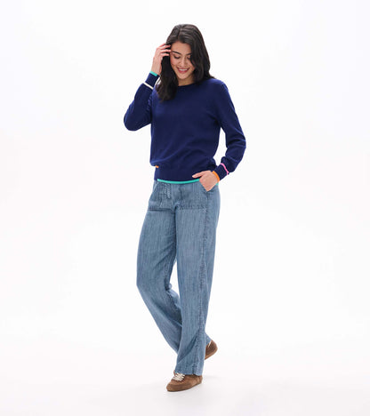 Front angled view of patriot blue crew neck sweater with multicolor striped cuffs and hem
