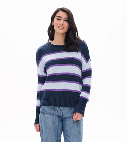 Front view of rolled collar sweater with navy, white, and purple stripes and ribbed hem