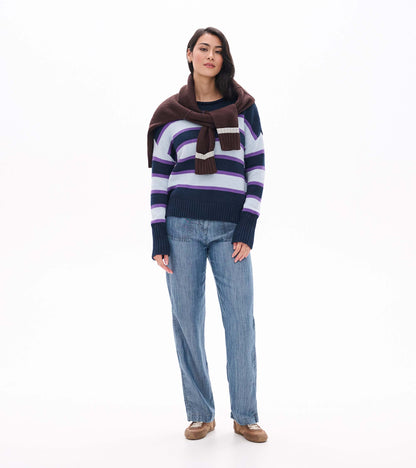 Front view of striped rolled collar sweater styled with a brown sweater draped over the shoulders